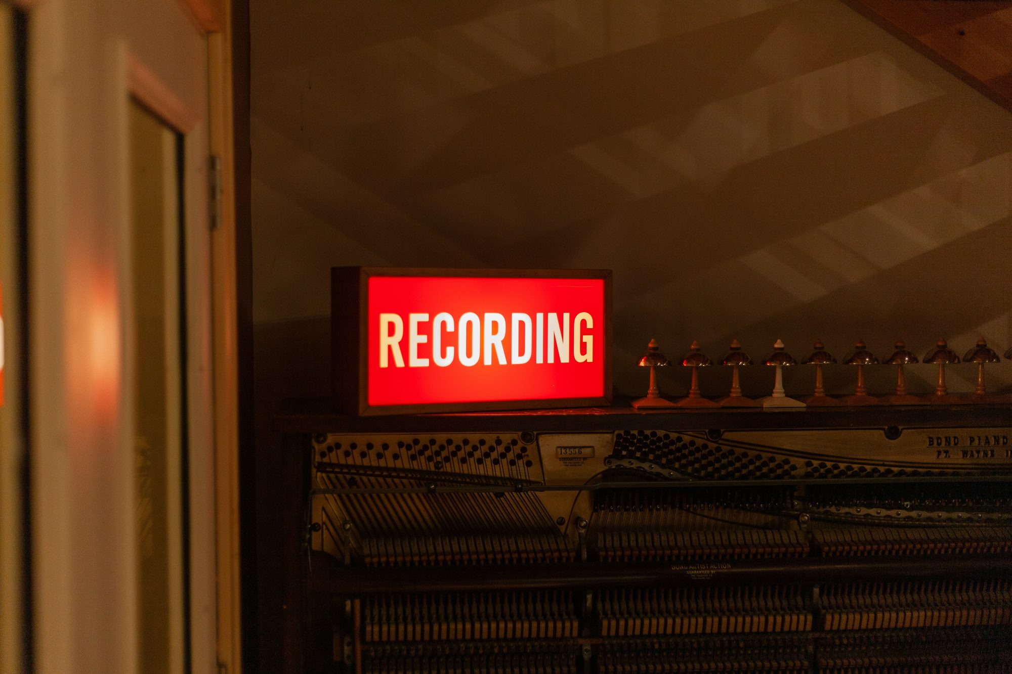 Recording sign lit up in a studio